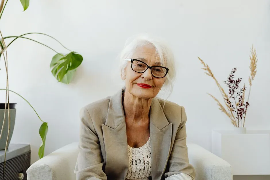 Femme âgée souriante assise dans un séjour lumineux